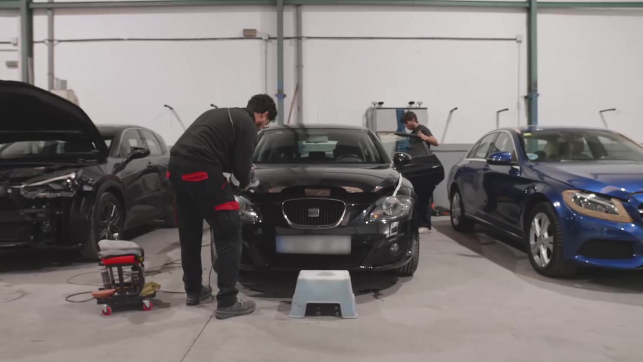 Interior de VR Chapa y Pintura con el equipo trabajando en varios vehículos